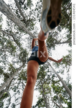 Adventurous Woman Overcoming Forest Obstacles with Determination and Agility. 131404541