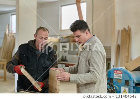 Production Manager Demonstrating Woodcraft Techniques to Employee for Decorative and Residential Items 131404542