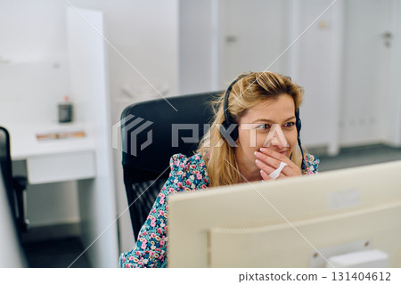 Friendly Call Center Agent Answering Incoming Calls with Headset Providing Remote Customer Service. 131404612