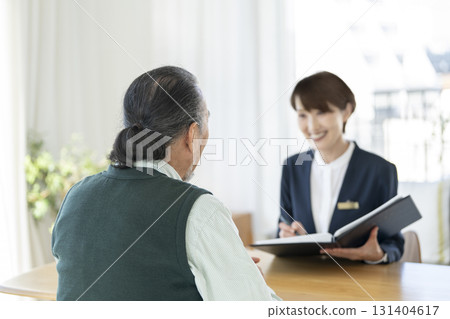 Rear view of a senior man listening to a saleswoman 131404617