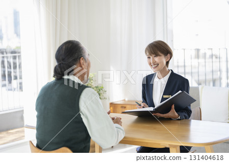 A middle-aged businesswoman talking to a senior man 131404618