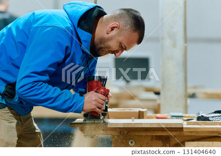 Close Up of Worker Carefully Cutting and Planing Wooden Pieces for Furniture in Wood Industry 131404640