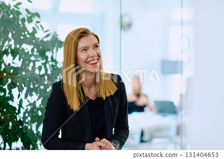 Portrait of a Blonde Businesswoman in a Modern Office with Her Workspace and Colleagues in the Background. 131404653