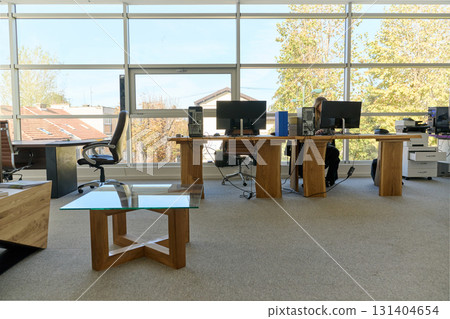 Modern Office Interior with Wooden Furniture, Conference Table, and Computers 131404654