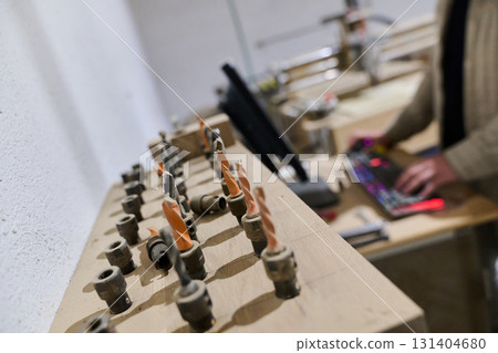Operator Entering Coordinates on Computer for CNC Machine to Precisely Cut Wooden Pieces 131404680
