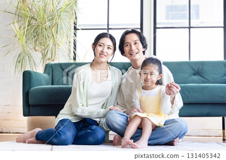 一個在客廳裡放鬆的年輕家庭 131405342