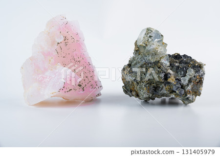 Pink manganoan calcite with cubic fluorite crystal, pyrite inclusions, and galena lead glance, mineral specimen on white background from Russia. 131405979
