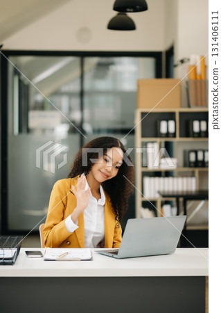 Business woman Talking on the phone and using a laptop at office Business woman Talking on the phone and using a laptop at office 131406111