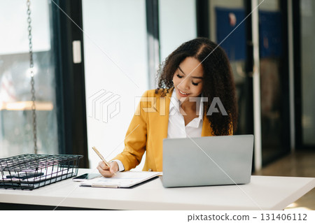 Business woman Talking on the phone and using a laptop at office 131406112