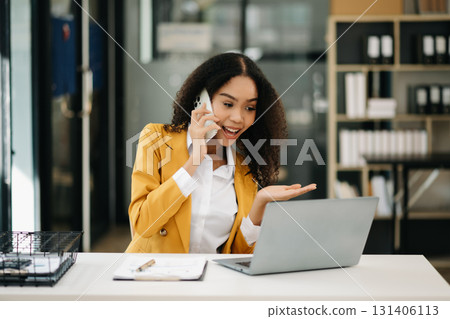 Business woman Talking on the phone and using a laptop at office 131406113