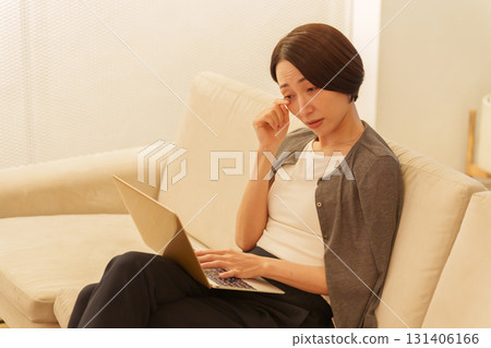 一位女士晚上在電腦前工作時眼睛疲勞 131406166