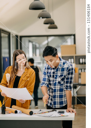 Two colleagues discussing data working and tablet, laptop with architectural project at construction site at desk 131406184
