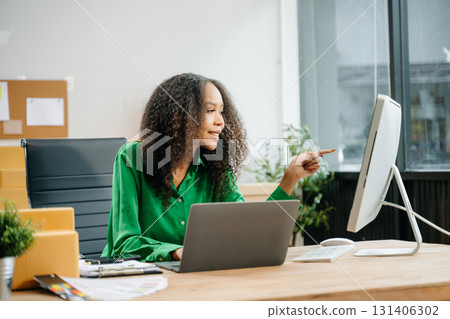 Young business owner woman prepare parcel box and standing check online orders for deliver 131406302