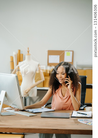 Young entrepreneur working in a creative workspace, surrounded by packaging, boxes Young entrepreneur working in a creative workspace, surrounded by packaging, boxes 131406306