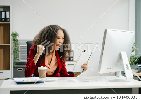Confident business expert attractive smiling young woman holding digital tablet  on desk in creative office. 131406335