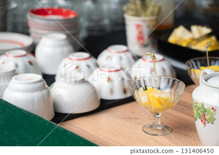 Traditional porcelain bowls with floral patterns displayed on a table alongside glass cups of fresh fruit Traditional porcelain bowls with floral patterns displayed on a table alongside glass cups of fresh fruit 131406450