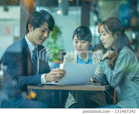 A man in a suit consulting a young couple at a cafe while showing them graphs, business, consultation, meeting, conference, 131407242