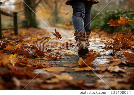 Barefoot child playing in colorful autumn leaves on pathway Barefoot child playing in colorful autumn leaves on pathway 131408054