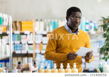 Middle-aged man with prescription looking for products in pharmacy Middle-aged man with prescription looking for products in pharmacy 131408550