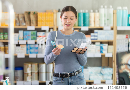 Young girl choosing cosmetics in chemist's shop Young girl choosing cosmetics in chemist's shop 131408556
