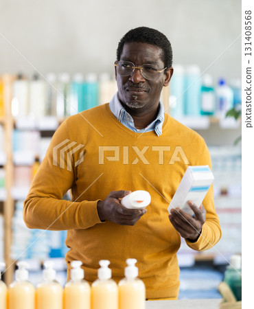 African man buyer select cream in drug store African man buyer select cream in drug store 131408568