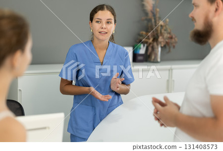 female administrator communicates with clients of a dental clinic 131408573