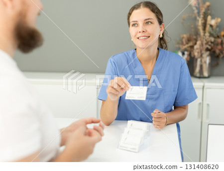 Female dentist offers her patients business card Female dentist offers her patients business card 131408620