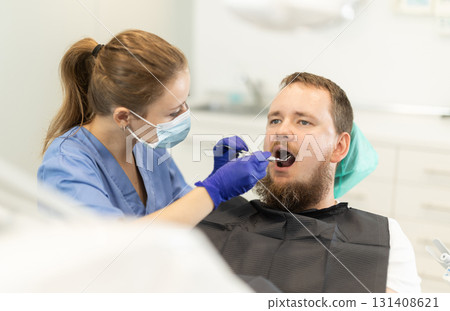 man sits in a chair at an appointment at a dental clinic 131408621