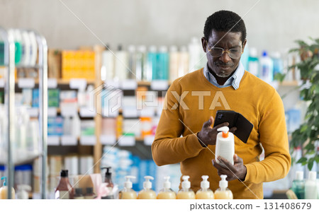 Male customer using smartphone to choose skincare product in pharmacy Male customer using smartphone to choose skincare product in pharmacy 131408679