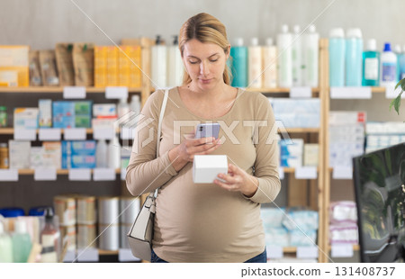 Pregnant woman scanning qr code of pills Pregnant woman scanning qr code of pills 131408737