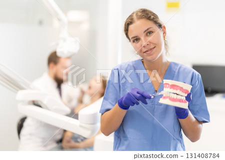 Portrait of a female dentist holding prosthetic jaw 131408784