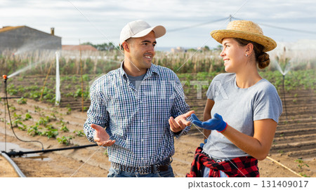 Man and girl farmers talking friendly in field during break in work 131409017