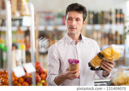 Man choosing pasta in the supermarket Man choosing pasta in the supermarket 131409070
