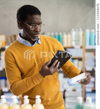 Customer scanning QR code on box of ointment in pharmacy 131409076