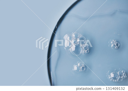 Close-up of bubbles in transparent gel on light blue background 131409132