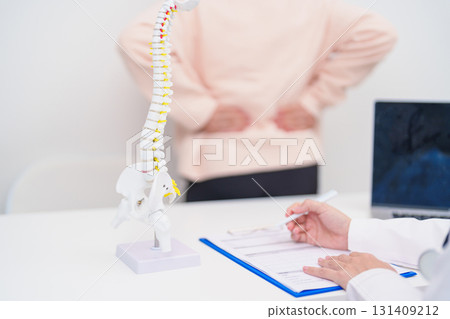 Elderly Patient consulting Doctor with Spine anatomy for Spinal Cord Disorder and disease, Back pain, Lumbar, Sacral pelvis, Cervical neck, Thoracic, Coccyx, Orthopedist, chiropractic, Office Syndrome 131409212