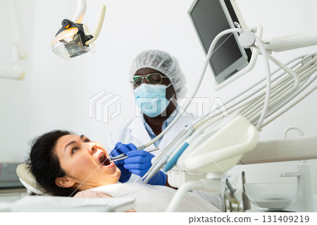 Dentist examining oral cavity of woman in dental clinic Dentist examining oral cavity of woman in dental clinic 131409219
