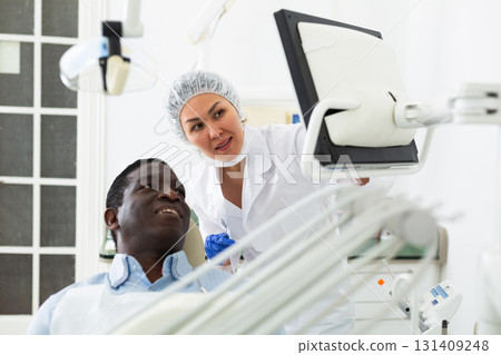 Doctor dentist shows the patient the result of dental x-ray Doctor dentist shows the patient the result of dental x-ray 131409248