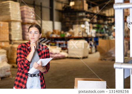 Young woman inspecting storehouse 131409256