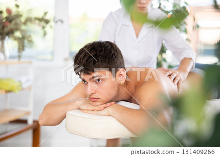 Relaxing happy man getting back massage in spa center 131409266