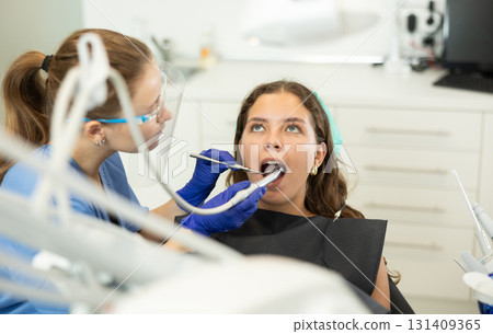 Woman dentist drilling and treating teeth of woman in clinic Woman dentist drilling and treating teeth of woman in clinic 131409365