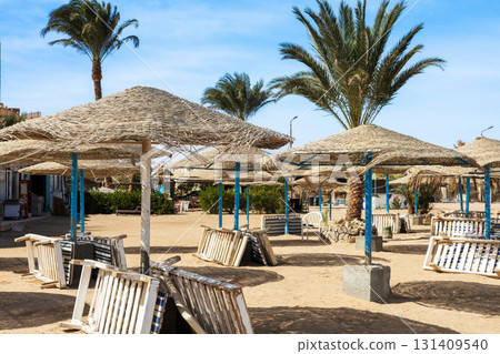 Serene beachfront cabana retreat with rustic wooden sun loungers and palm trees 131409540