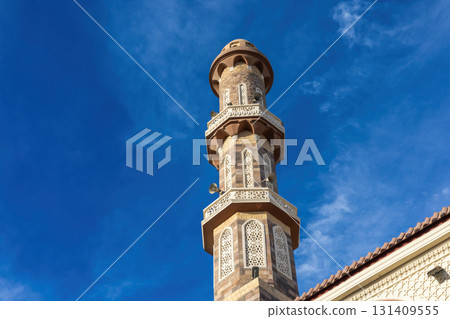 Architectural marvel of an ornate minaret against a clear blue sky 131409555
