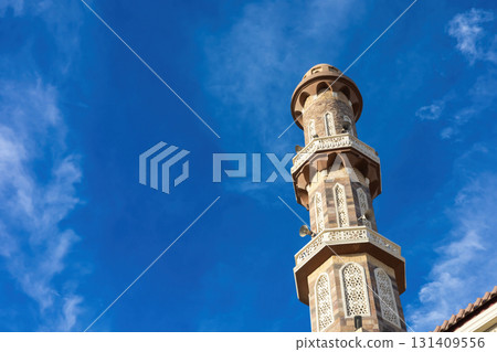 Majestic mosque minaret against vibrant blue sky perfect for travel and architecture inspiration Majestic mosque minaret against vibrant blue sky perfect for travel and architecture inspiration 131409556