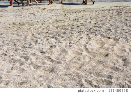 Beach walk with footprints on sandy shore, ideal for travel and leisure themes Beach walk with footprints on sandy shore, ideal for travel and leisure themes 131409558