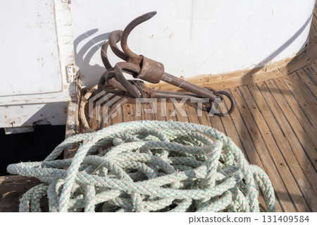 Nautical equipment on wooden deck with rope and vintage anchor Nautical equipment on wooden deck with rope and vintage anchor 131409584