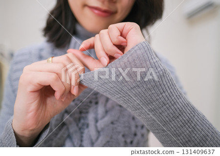 A fashion influencer showing off a close-up look at grey knitwear A fashion influencer showing off a close-up look at grey knitwear 131409637