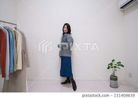 一位時尚達人展示了灰色夾克和藍色裙子的搭配 一位時尚達人展示了灰色夾克和藍色裙子的搭配 131409639