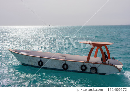 Tranquil ocean scene with a boat on turquoise waters under a clear sky Tranquil ocean scene with a boat on turquoise waters under a clear sky 131409672