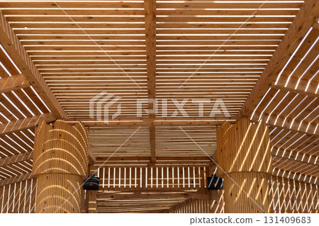 Architectural pattern of wooden slats creating symmetrical shadows and light Architectural pattern of wooden slats creating symmetrical shadows and light 131409683